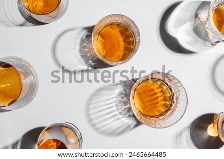 Glasses of whiskey on table near decanter and cinnamon