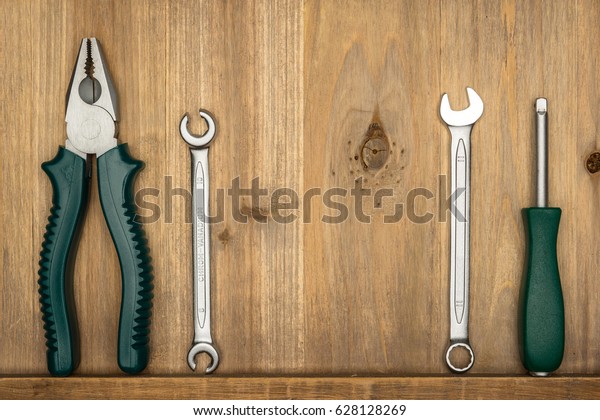 Top view of different type of constructive tools\
with copy space on wooden background. Construction instruments and\
car tools. Home tool kit. Everyday instruments. Work stuff. Mend\
and repair.