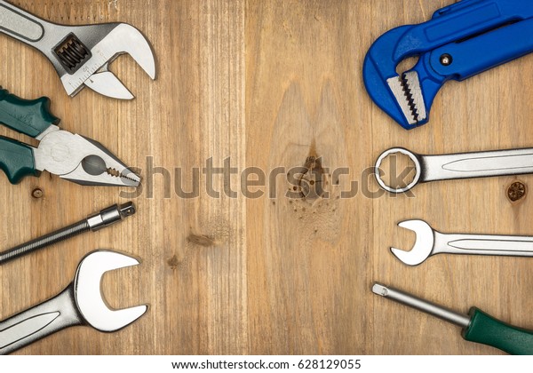 Top view of different type of constructive tools
with copy space on wooden background. Construction instruments and
car tools. Home tool kit. Everyday instruments. Work stuff. Mend
and repair.
