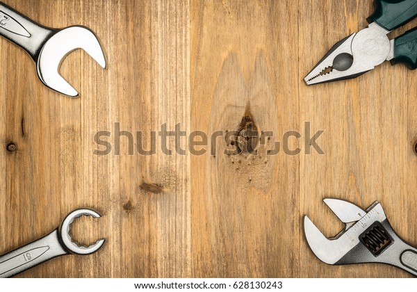 Top view of different type of constructive tools\
with copy space on wooden background. Construction instruments and\
car tools. Home tool kit. Everyday instruments. Work stuff. Mend\
and repair.