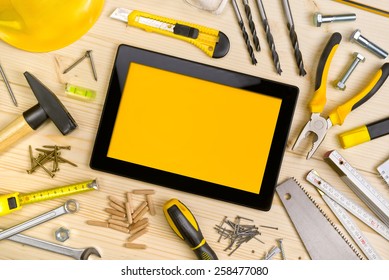 Top View of Digital Tablet and Assorted Woodwork and Carpentry Tools on Pinewood Workshop Table - Powered by Shutterstock