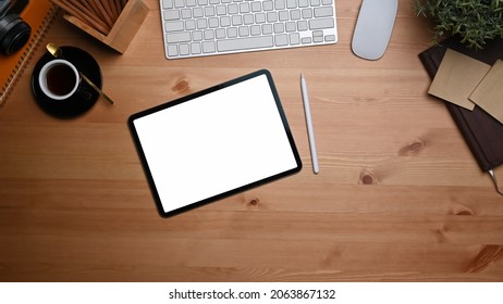Top view digital tablet with empty display, sticky note and coffee cup on wooden table. - Shutterstock ID 2063867132