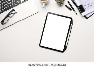 Top view digital tablet with empty scree, laptop and document on white office desk