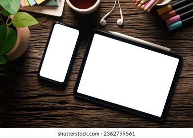 Top view digital tablet and mobile phone with blank screen on wooden table.