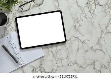 Top view of digital tablet with white empty screen, headphone and coffee cup on marble table - Shutterstock ID 2310732931