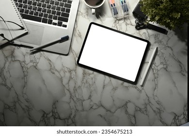 Top view of digital tablet with white empty screen, laptop, notepad and coffee cup on marble background - Shutterstock ID 2354675213