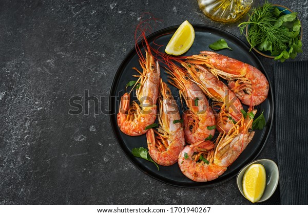 Top view of dining table with red big prawns\
and coocking ingredients