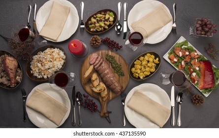 Top View Of A Dinner Table. Roast Beef, Cauliflower Salad, Brussels Sprouts, Smoked Salmon, Garlic Bread, Candle, Rice, Turkey & Red Wine. 