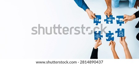 A top view of diverse hands assembling blue puzzle pieces on a white surface, symbolizing teamwork, collaboration, and strategic planning in a business environment. Amity