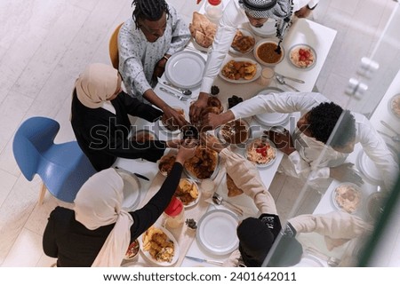 Top view of diverse hands of a Muslim family delicately grasp fresh dates, symbolizing the breaking of the fast during the holy month of Ramadan, capturing a moment of cultural unity, shared tradition