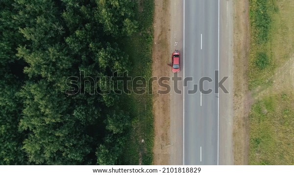 Top view of dividing line of\
forests and fields. Scene. Cars are driving on country highway with\
forest strip. Highway divides forest zone and\
field