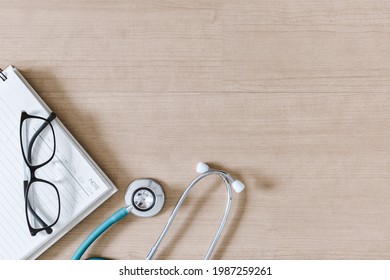 Top View Of Doctor Workspace With Stethoscope And Personal Equipment On Table Desk, Above View Of Doctor Working Space At Clinic Hospital. Health Medical Occupation And Business Healthcare Concept