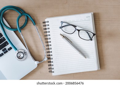 Top View Of Doctor Workspace With Stethoscope And Personal Equipment On Table Desk, Above View Of Doctor Working Space At Clinic Hospital. Health Medical Occupation And Business Healthcare Concept