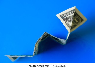 A Top View Of A Dollar Banknote Money Making A Rocket Origami Isolated On A Blue Background