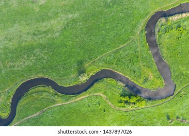 Top View Drone Shot Of A Green Field And River