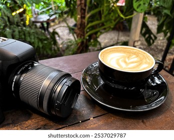 Top view of DSLR camera and creamy coffee latte on wooden table - Powered by Shutterstock