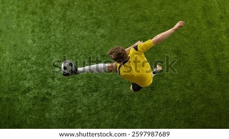 Top view dynamic image of young man, professional soccer player in motion with ball on green stadium, playing, competing for victory. Concept of sport, action, competition, game, active lifestyle. Ads