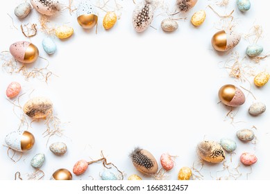 Top view of Easter eggs colored with golden paint in different patterns. White background. Copy space.