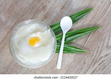 Top View Of Egg And Young Coconut In Coconut Water In A Cup Is A Thai Dessert On Wooden Table.