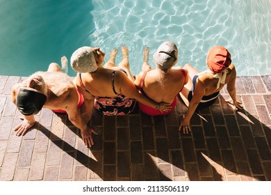 Top View Of Elderly People Relaxing With Their Legs In The Swimming Pool. Serene Senior Citizens Enjoying Their Summer Vacation At A Spa Resort. Mature Friends Enjoying Themselves After Retirement.