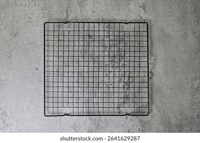 Top view of empty black baking rack. grey or gray cement as background. Copy space, empty space, free space for food photo. High angle, above. flat lay.