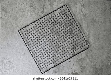 Top view of empty black baking rack. grey or gray cement as background. Copy space, empty space, free space for food photo. High angle, above. flat lay.