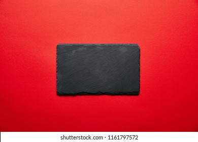 Top View Of Empty Black Slate Plate For Sushi Isolated On Red