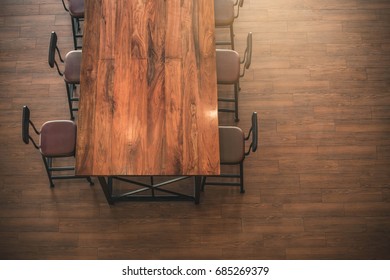 Top View Of Empty Brown Wooden Table And Coffee Shop Interior.