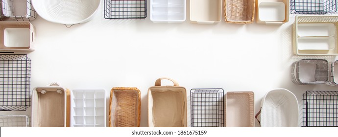 Top View Of Empty Closet Organization Boxes And Steel Wire Baskets In Different Shape Placed On White Marble Table With Copy Space. Marie Kondo’s Hikidashi Boxes For Tidying Clothes And Drawer Storage