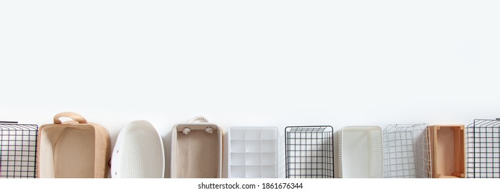 Top view of empty closet organization boxes and steel wire baskets in different shape placed on white marble table with copy space. Marie Kondo’s hikidashi boxes for tidying clothes and drawer storage