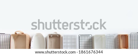 Top view of empty closet organization boxes and steel wire baskets in different shape placed on white marble table with copy space. Marie Kondo’s hikidashi boxes for tidying clothes and drawer storage