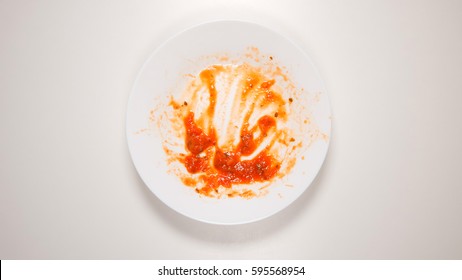 TOP VIEW: Empty And Dirty Dish After A Spaghetti With Tomato Sauce