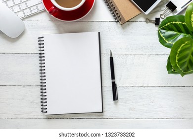 Top view, empty notebook with coffee and office supplies on the desk. - Shutterstock ID 1323733202