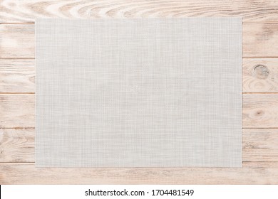 Top view of empty white tablecloth on wooden background with copy space.