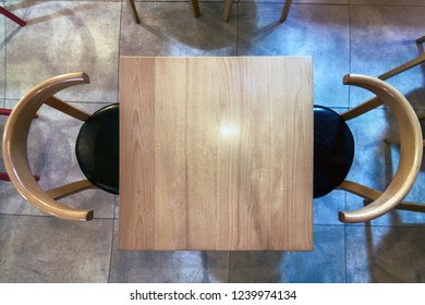 Top View Empty Wooden Table And Chairs In Coffee Shop