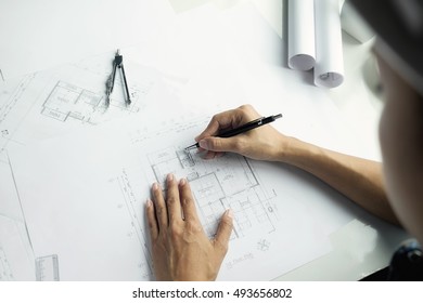 Top view of engineer hand working on blueprint.Construction concept. Engineering tools.Vintage tone retro filter effect,soft focus(selective focus) - Shutterstock ID 493656802