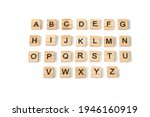 Top view of english alphabet made of square wooden tiles with the English alphabet scattered on a white background with space for text. The concept of thinking development, grammar.