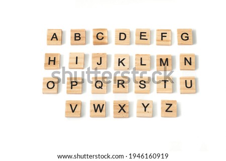 Top view of english alphabet made of square wooden tiles with the English alphabet scattered on a white background with space for text. The concept of thinking development, grammar.
