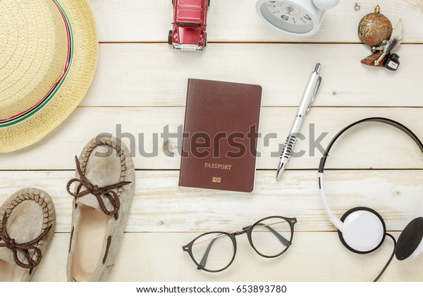 Top\
view essential travel items.The shoes notebook tree map passport\
airplane car eyeglasses on rustic  wooden\
background.