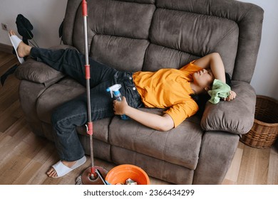 Top view of exhausted woman sleeping on couch during cleaning house - Shutterstock ID 2366434299