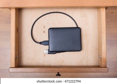 top view of external computer hard drive in open drawer of nightstand - Shutterstock ID 471222794