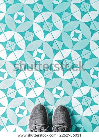 Top view of fabric shoes on a mosaic tile floor with copy space