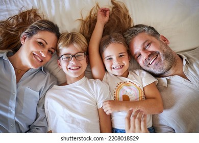 Top View, Family Or Children Bonding In Bedroom In House, Home Or Hotel And Parents In Trust, Love Or Security. Portrait, Smile Or Happy Kids With Mature Father And Mother Or Man And Australian Woman