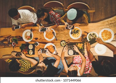 

Top View Family And Friends Sit Down, Take A Photo Of Food On The Table And Have Fun Before Eating.
