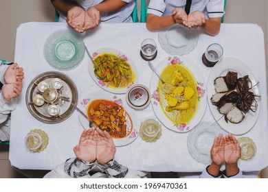 Top View Of Family Hands Praying Before Eat With Menu Served On The Table During Eid Mubarak 