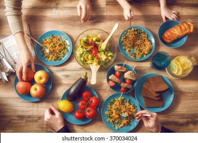 Top View Of Family Having Dinner Together Sitting At The Rustic Wooden Table. Enjoying  Family Dinner Together.