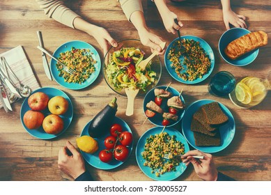 Top View Of Family Having Dinner Together Sitting At The Rustic Wooden Table. Enjoying  Family Dinner Together.