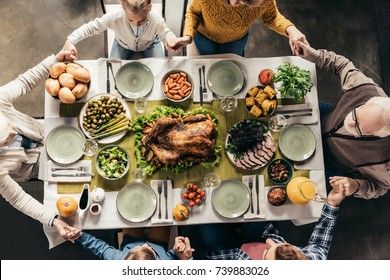 Top View Of Family Praying Before Holiday Dinner