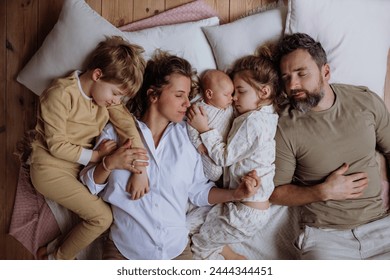 Top view of family sleeping in bed with kids and newborn baby. Perfect moment. Strong family, bonding and parents' unconditional love for their children. - Powered by Shutterstock