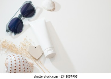 top view with fashio sunglasses summer concept of spa sea beach beauty cosmetic body lotion cream aroma perfume sunscreen spf mockup package product with shell and flower on table